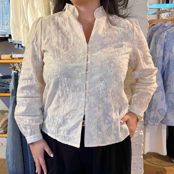 Broderad blus med små dekorativa knappar