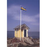 Gul stuga vid havet med flagga