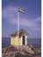 Gul stuga vid havet med flagga