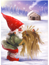 Tomte framför stuga med kärve
