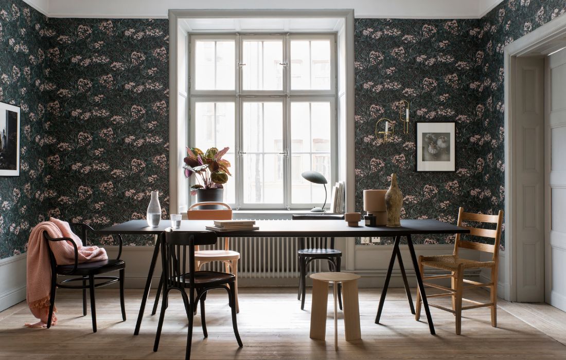 Tapeten Malin från Sandberg, här i kombinerad matsal och vardagsrum med svart och trärena möbler.
